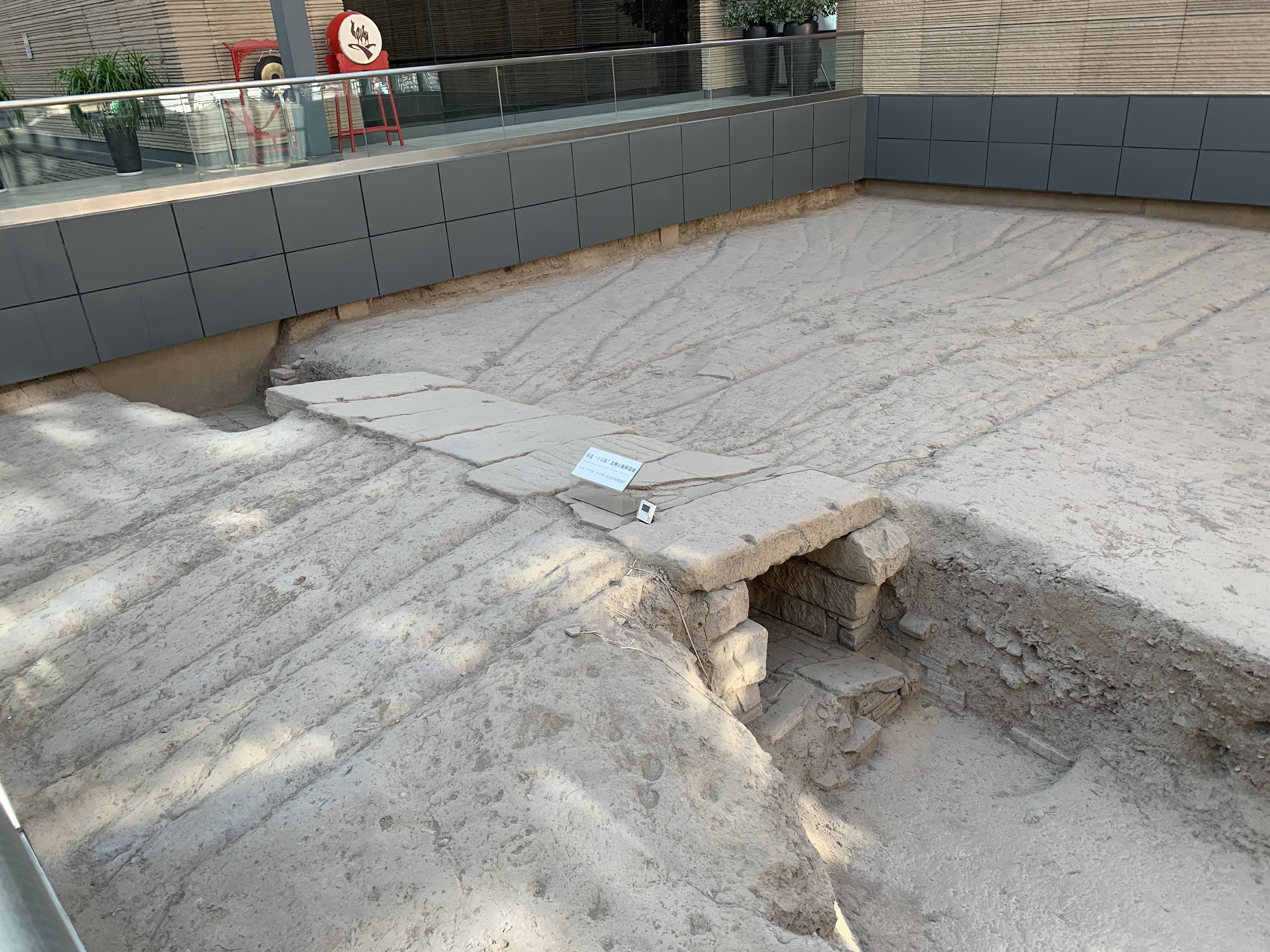 The excavation of an ancient bridge in the middle of a modern city street.